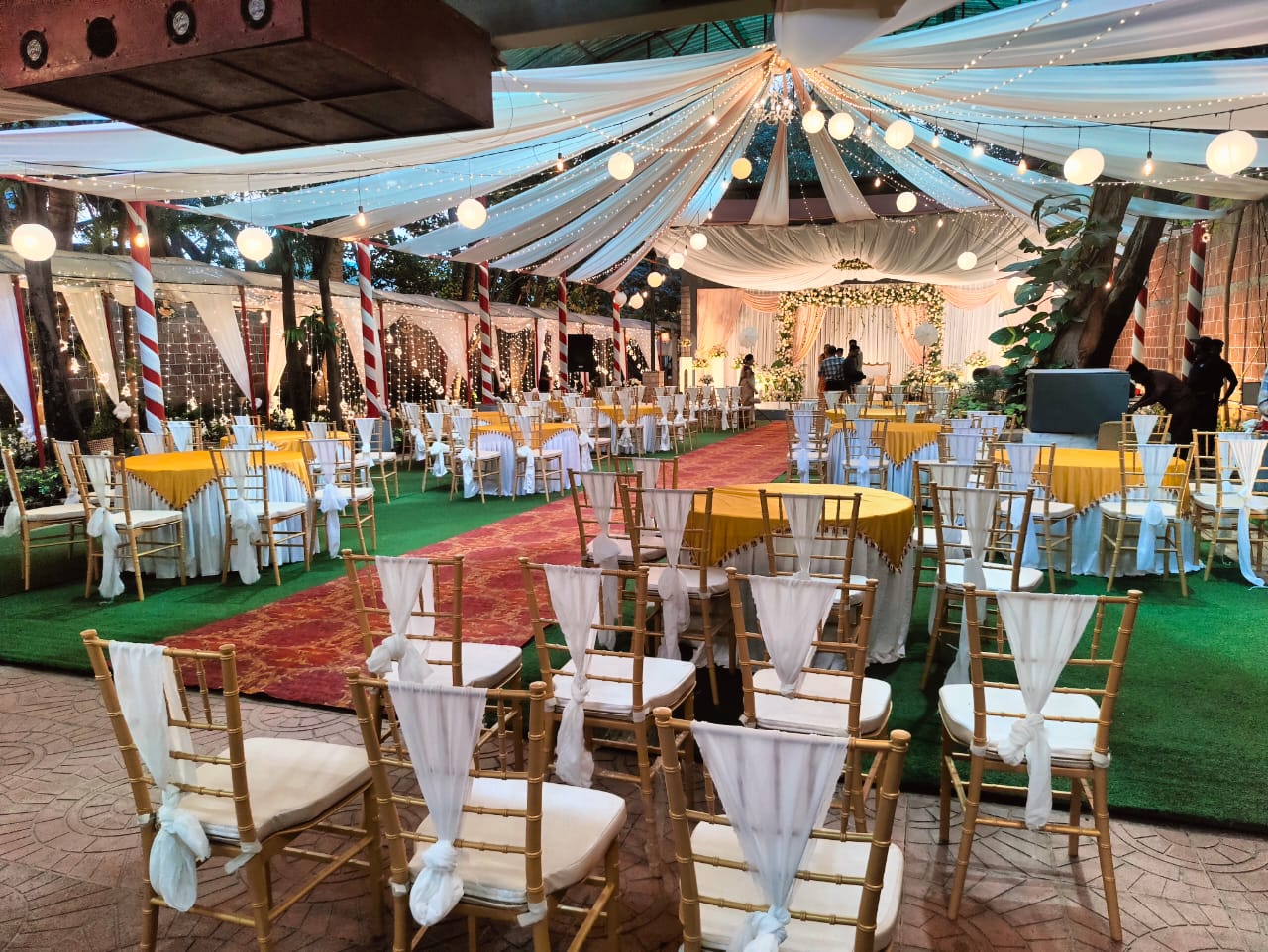 Pergola grand ballroom styled with an ivory aisle and floral reception tables.